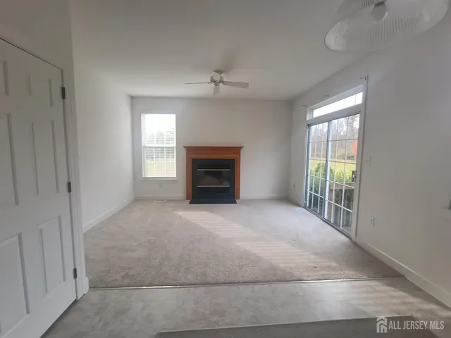 en empty room with windows and fireplace