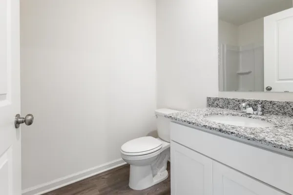 a bathroom with a granite countertop sink and a toilet