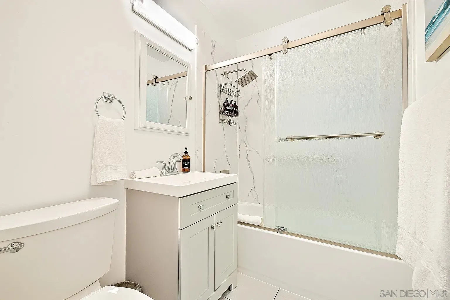 965 Rosecrans Street San Diego, CA 92106 - Photo 11 of 12 a bathroom with a sink a toilet and a mirror