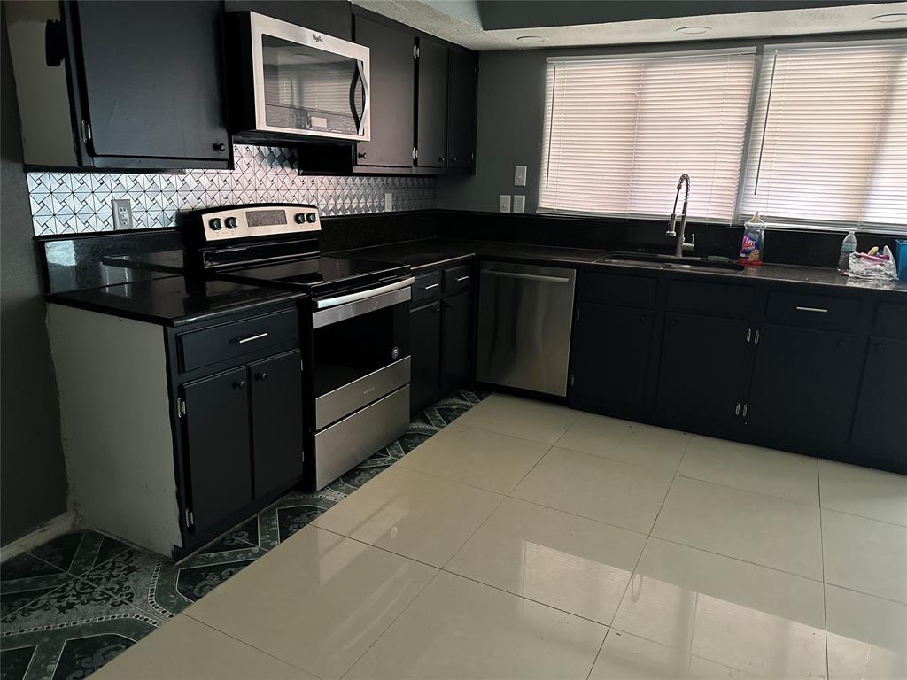 4601 Elm Ridge Lane Garland, TX 75044 - Photo 2 of 20 a kitchen with a sink stove and microwave