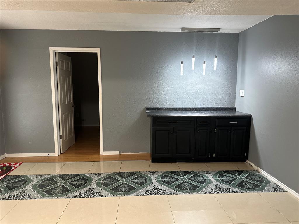 4601 Elm Ridge Lane Garland, TX 75044 - Photo 8 of 20 a room with a rug and a wooden floor