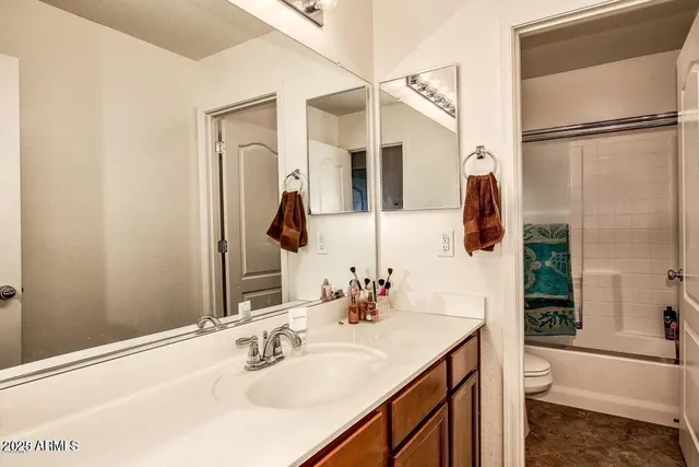 a bathroom with a granite countertop sink mirror and a bathtub