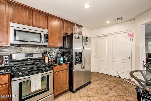 a kitchen with stainless steel appliances granite countertop a stove microwave and refrigerator