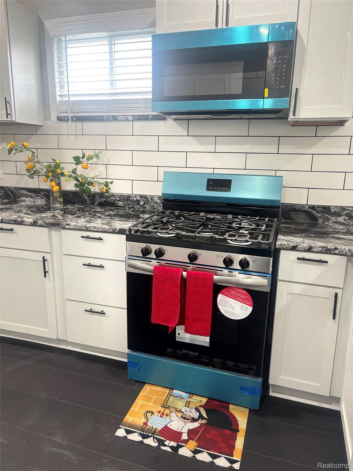 5012 Fischer Street Detroit, MI 48213 - Photo 3 of 22 Kitchen with stainless steel appliances, dark stone counters, white cabinetry, and decorative backsplash