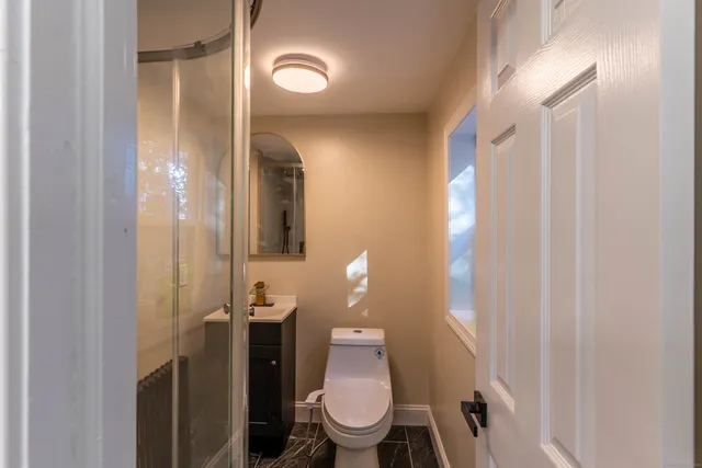 a bathroom with a toilet and a mirror