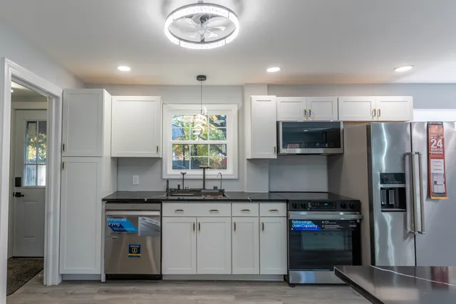 a kitchen with stainless steel appliances a sink stove and refrigerator