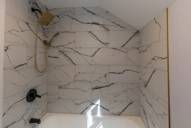 a bathroom with a bathtub and shower