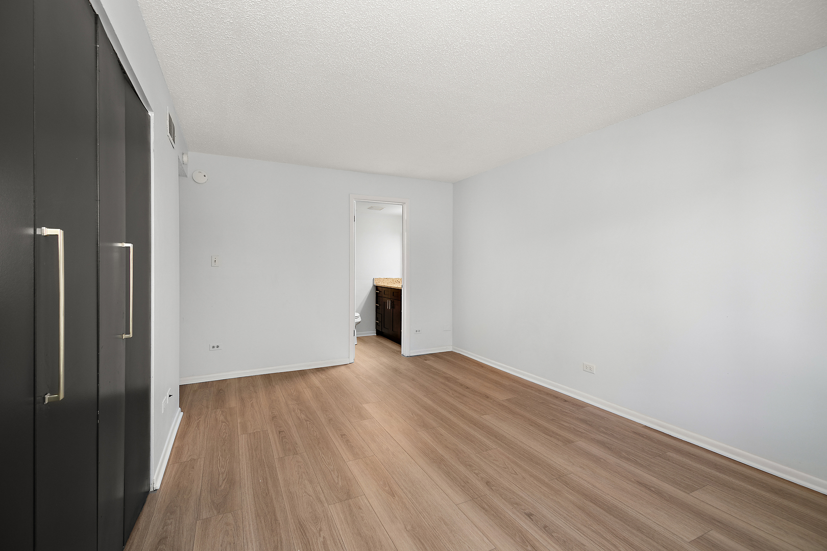 15717 Orlan Brook Drive, Unit 84 Orland Park, IL 60462 - Photo 13 of 18 a view of an empty room with wooden floor and a window