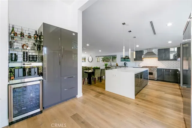 a kitchen with stainless steel appliances a stove a sink a oven a dining table and chairs