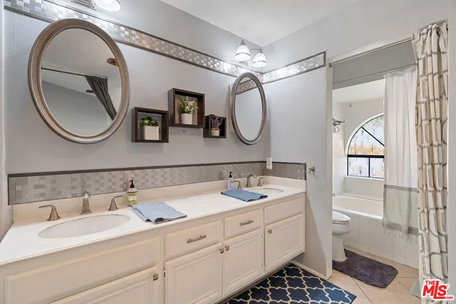 a bathroom with a double vanity sink and a mirror