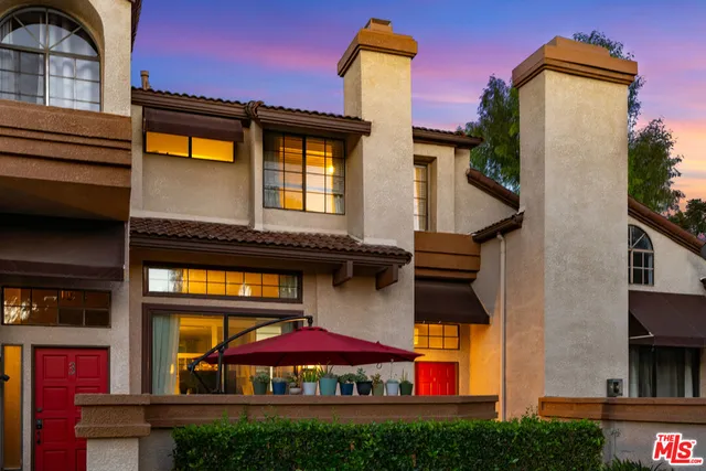 a front view of residential houses with an outdoor space and seating