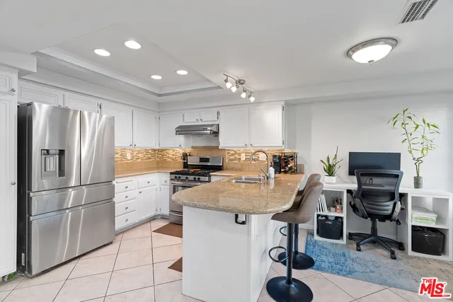 a kitchen with kitchen island a counter top space appliances and cabinets