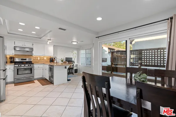 a kitchen with a refrigerator and a stove top oven