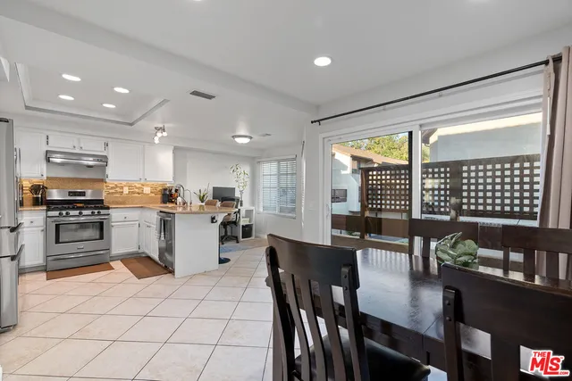 a kitchen with a refrigerator and a stove top oven