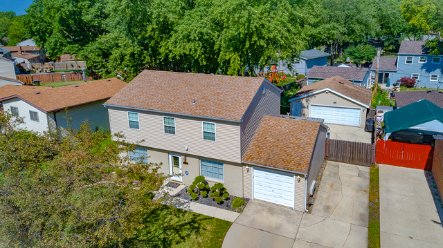 558 Redwood Road Bolingbrook, IL 60440 - Photo 3 of 12 an aerial view of a house with a yard potted plants and large tree