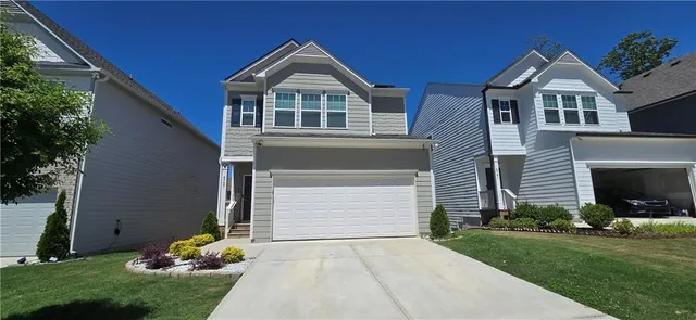 a front view of a house with a garden and plants