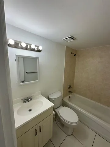 a bathroom with a toilet a sink a mirror and shower