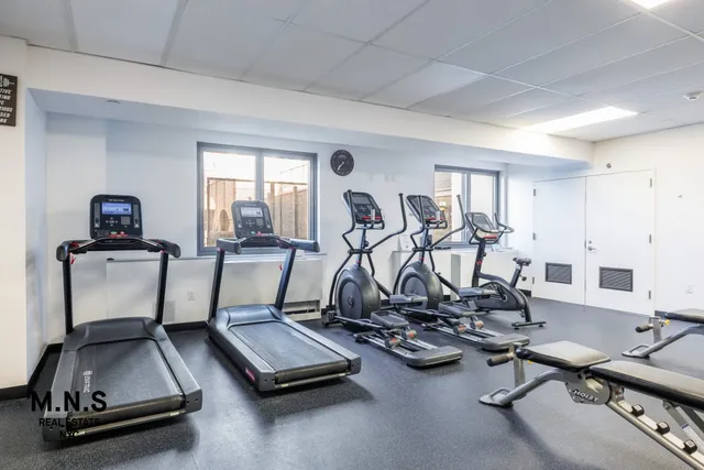 a room with gym equipment and windows