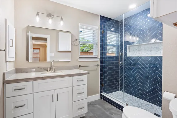a bathroom with a sink a toilet and shower