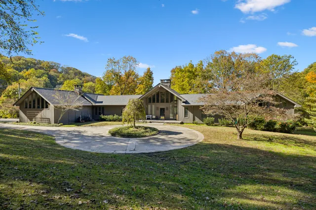 a front view of a house with a yard and potted plants