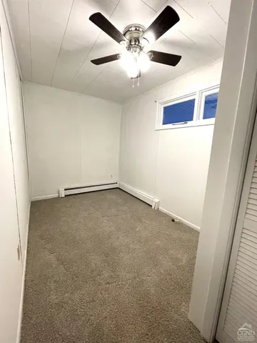 an empty room with a ceiling fan and a window