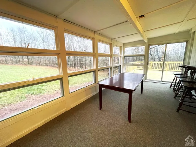 a view of a livingroom with furniture and floor to ceiling window