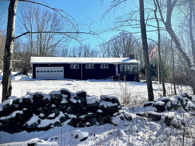 a view of a back yard of the house and cars parked