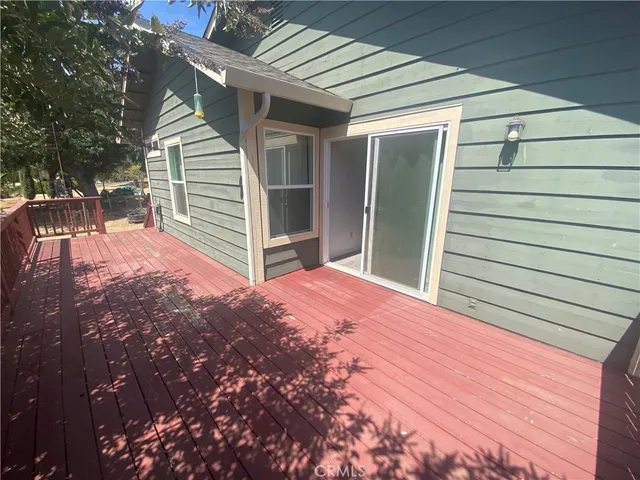 an empty room with wooden floor closet and windows