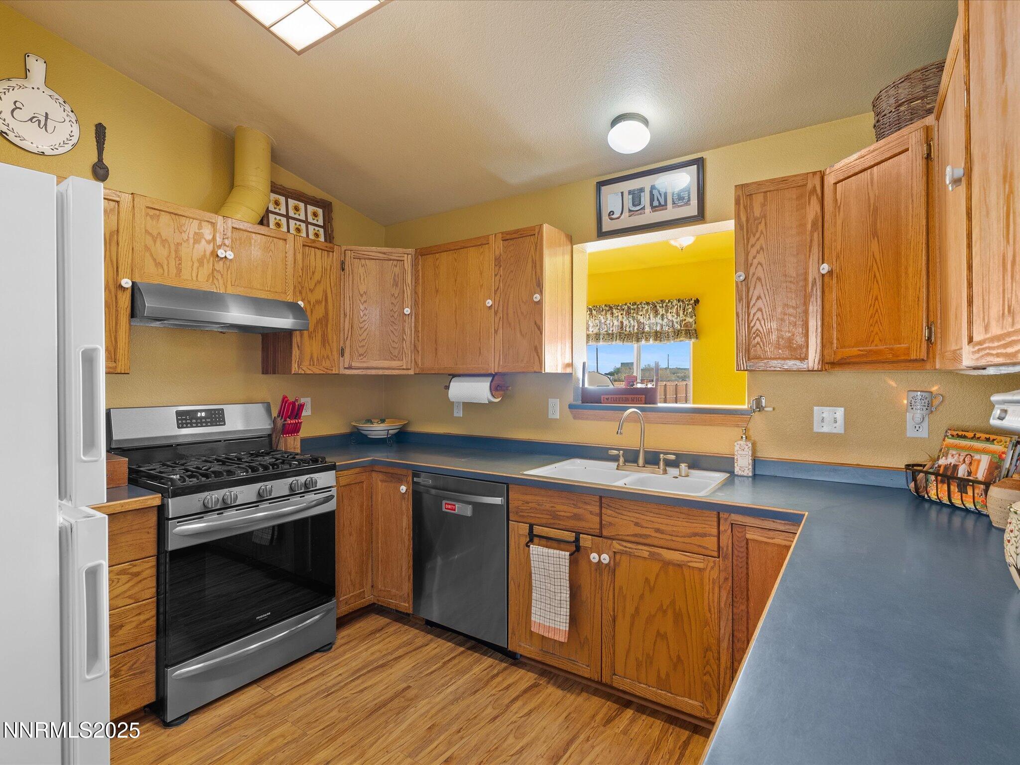 215 Hunter Park Way Fallon, NV 89406 - Photo 15 of 57 a kitchen with stainless steel appliances granite countertop wooden cabinets stove and a sink