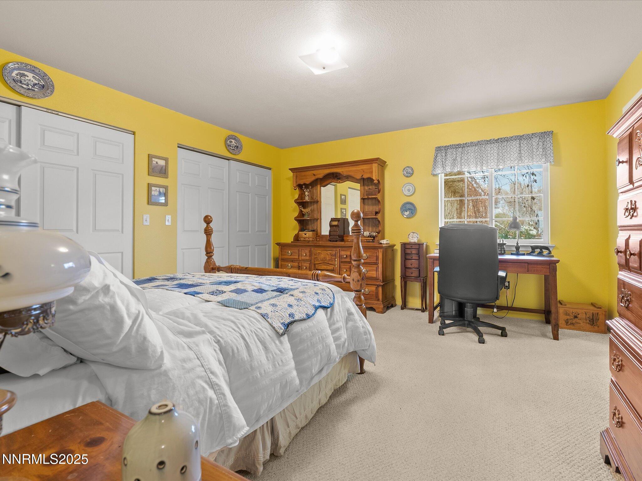 215 Hunter Park Way Fallon, NV 89406 - Photo 20 of 57 a bedroom with a bed gym equipment and large windows