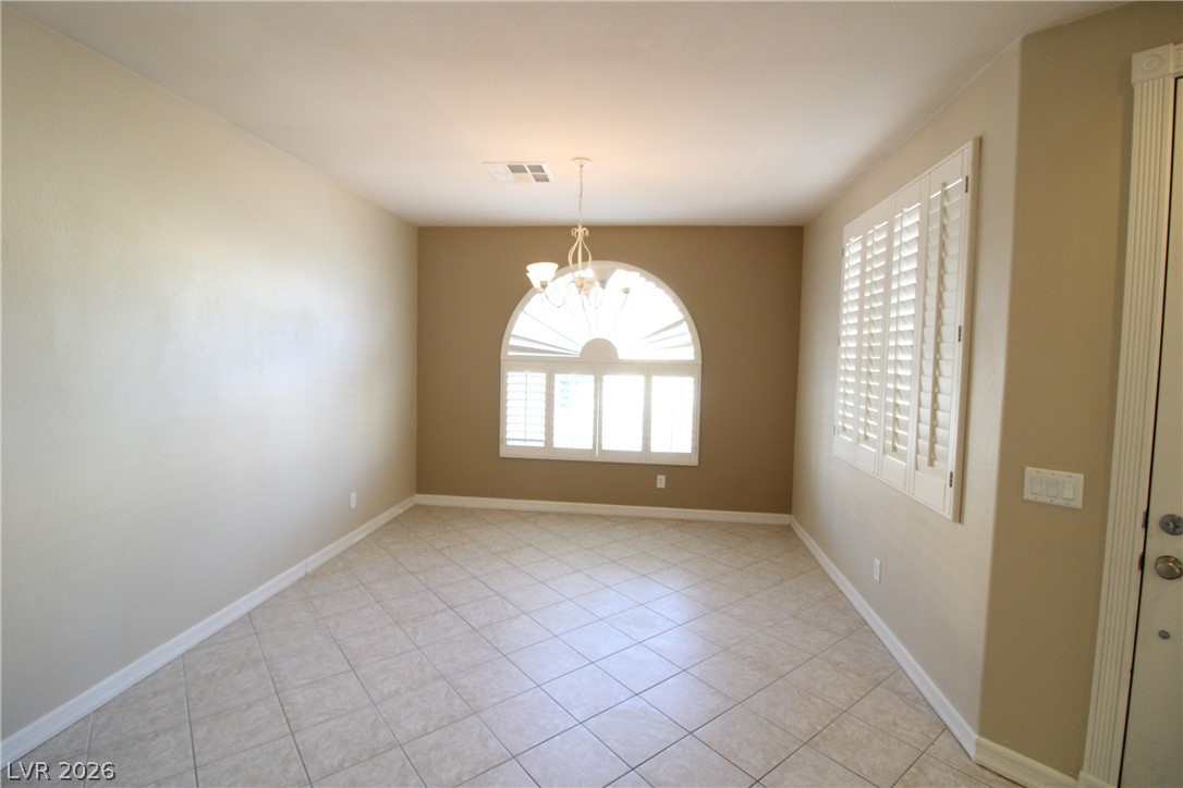 754 Rise Canyon Drive Henderson, NV 89052 - Photo 4 of 34 A well-lit room featuring elegant tile flooring and beautiful arched window with classic plantation shutters.
