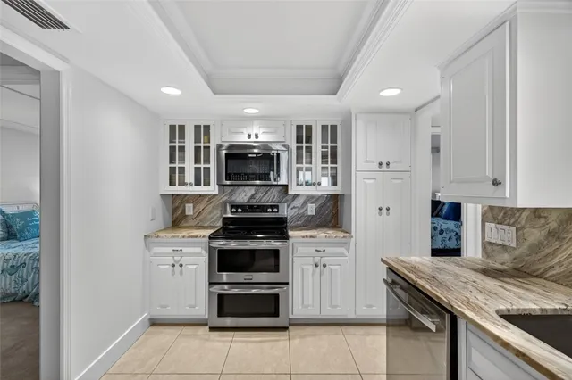 a kitchen with stainless steel appliances granite countertop a refrigerator and a stove top oven