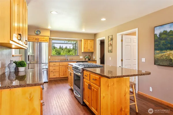 a kitchen with stainless steel appliances granite countertop a stove a sink and a refrigerator