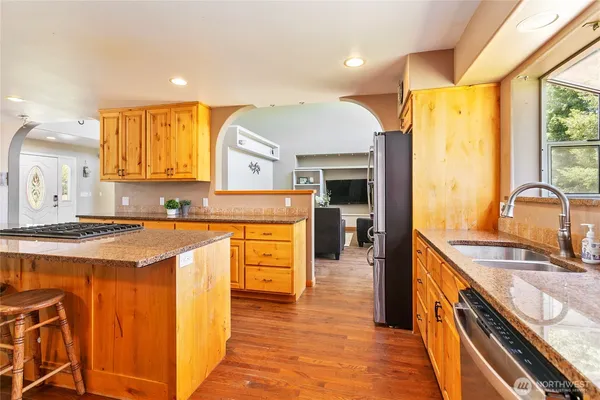 a kitchen with stainless steel appliances granite countertop a sink and a stove