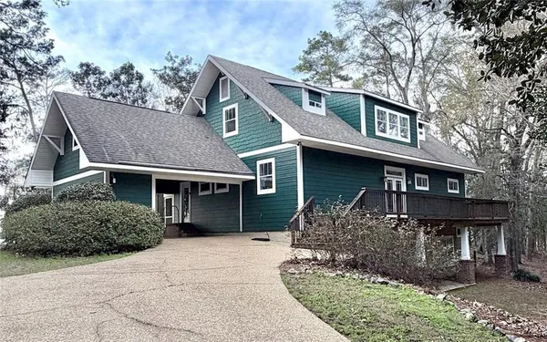 an aerial view of a house with a yard and lake view