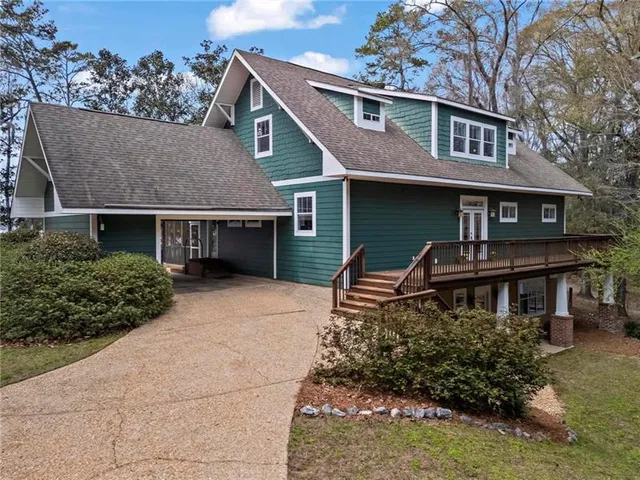 an aerial view of a house with a yard and lake view