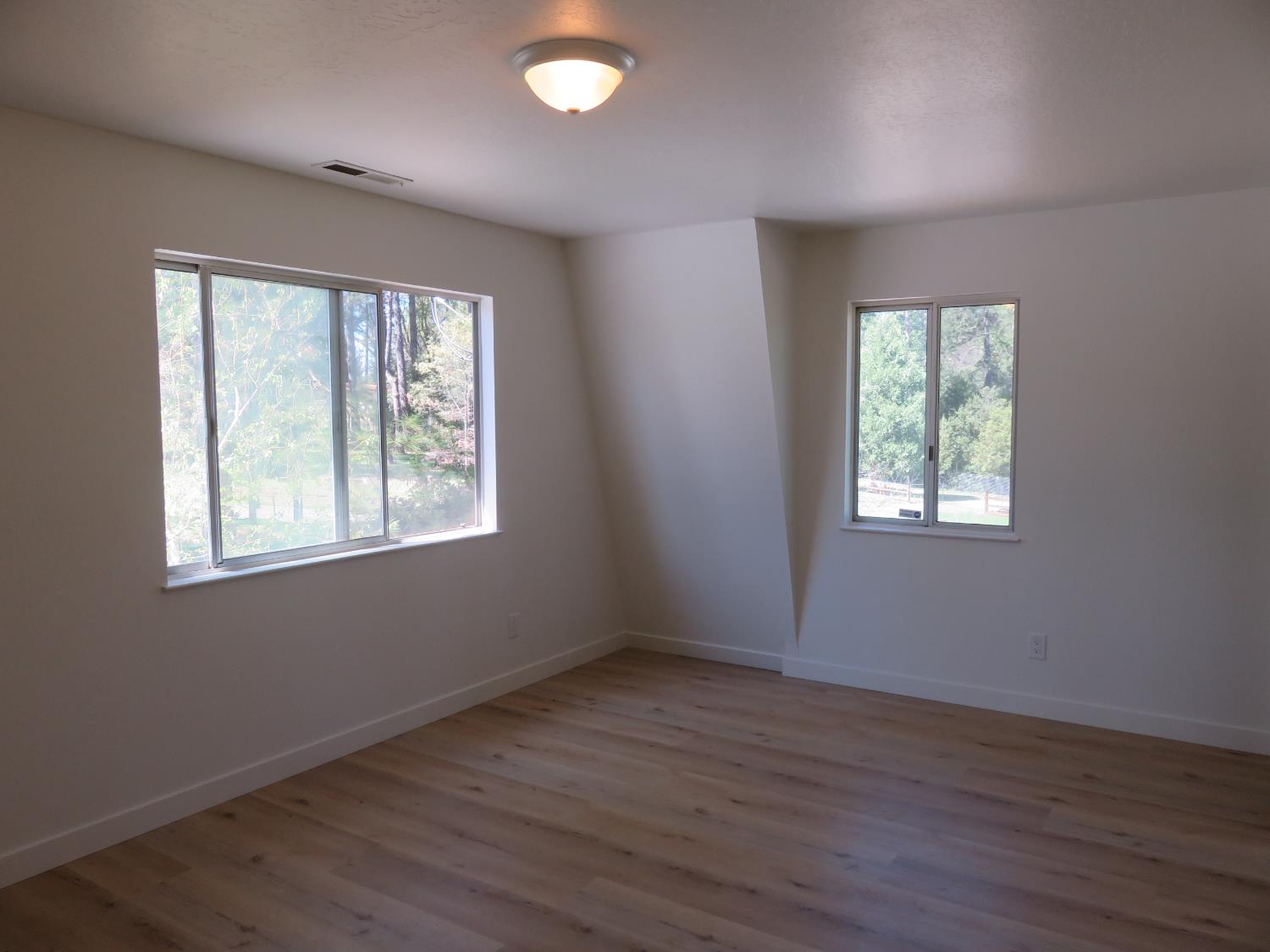 190 Bald Mountain Road West Point, CA 95255 - Photo 29 of 48 an empty room with wooden floor and windows
