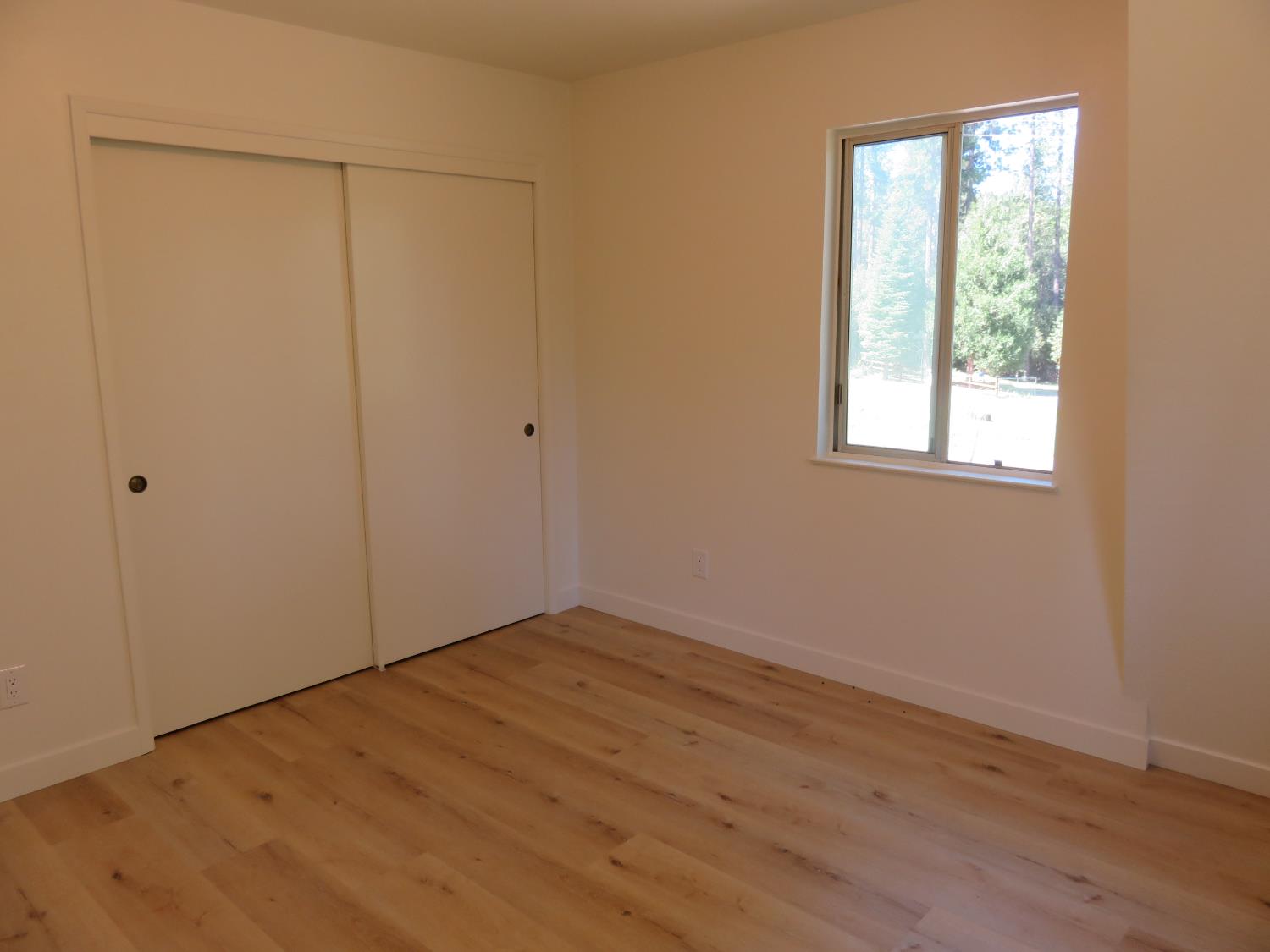 190 Bald Mountain Road West Point, CA 95255 - Photo 37 of 48 a view of an empty room with wooden floor and a window