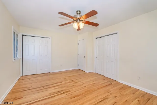 a view of a room with wooden floor and ceiling fan