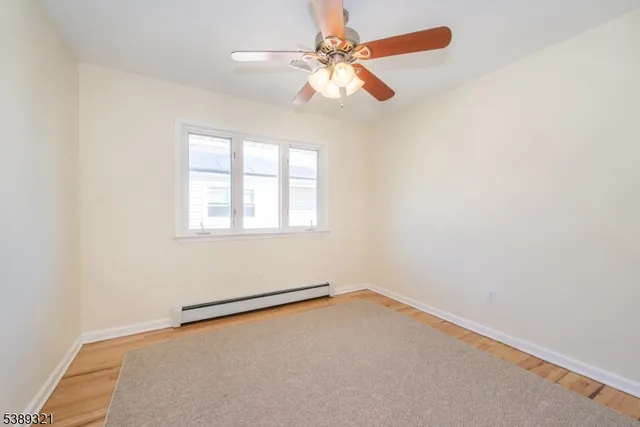 an empty room with a window and a fan
