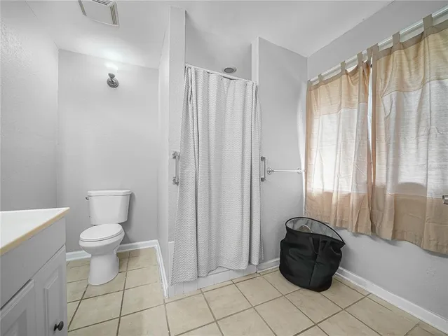 a bathroom with a toilet and a shower curtain