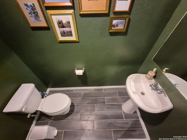 a bathroom with a toilet mirror and vanity