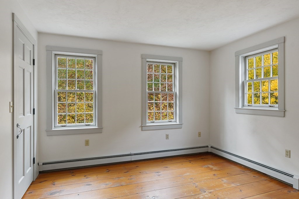 88 Bullard Road Princeton, MA 01541 - Photo 23 of 41 a view of an empty room with a window and wooden floor