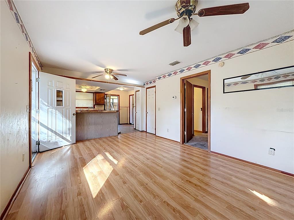 3175 Southwest 181st Court Dunnellon, FL 34432 - Photo 7 of 35 a view of a hallway with wooden floor and a kitchen