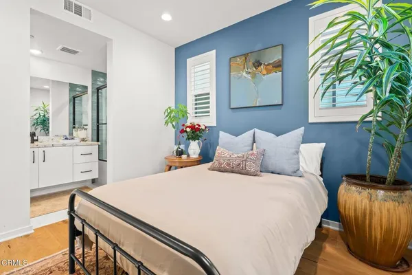 a bedroom with a bed and a potted plant