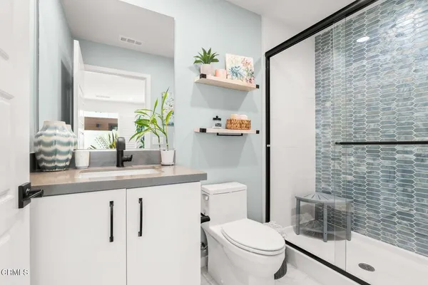 a bathroom with a sink a toilet and shower