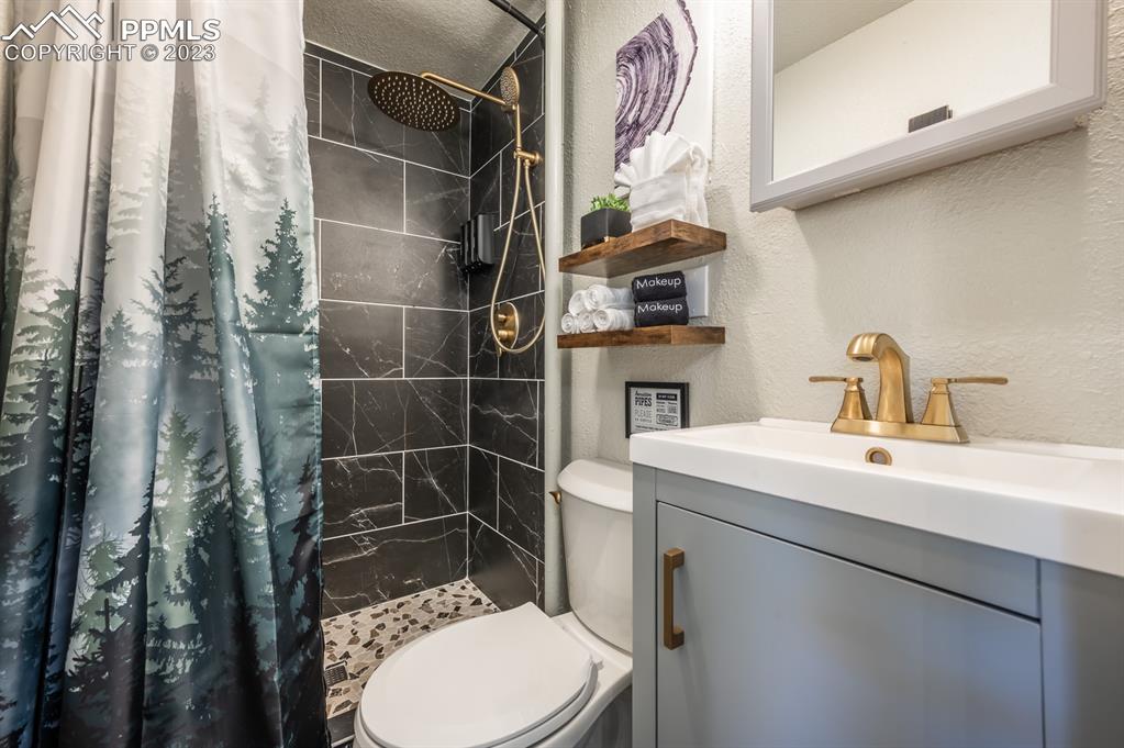627 Alexander Road Colorado Springs, CO 80909 - Photo 16 of 40 a bathroom with a sink toilet and shower