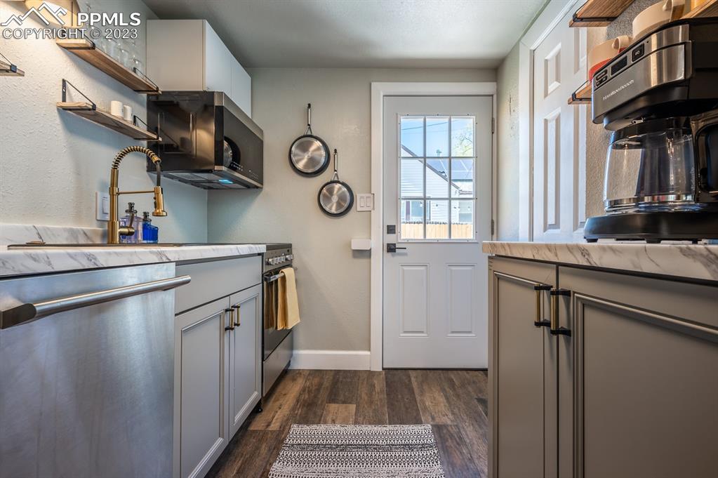 627 Alexander Road Colorado Springs, CO 80909 - Photo 32 of 40 a kitchen with a sink cabinets and a window