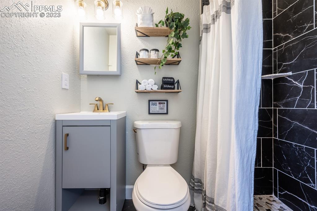 627 Alexander Road Colorado Springs, CO 80909 - Photo 35 of 40 a bathroom with a toilet a sink and a shower