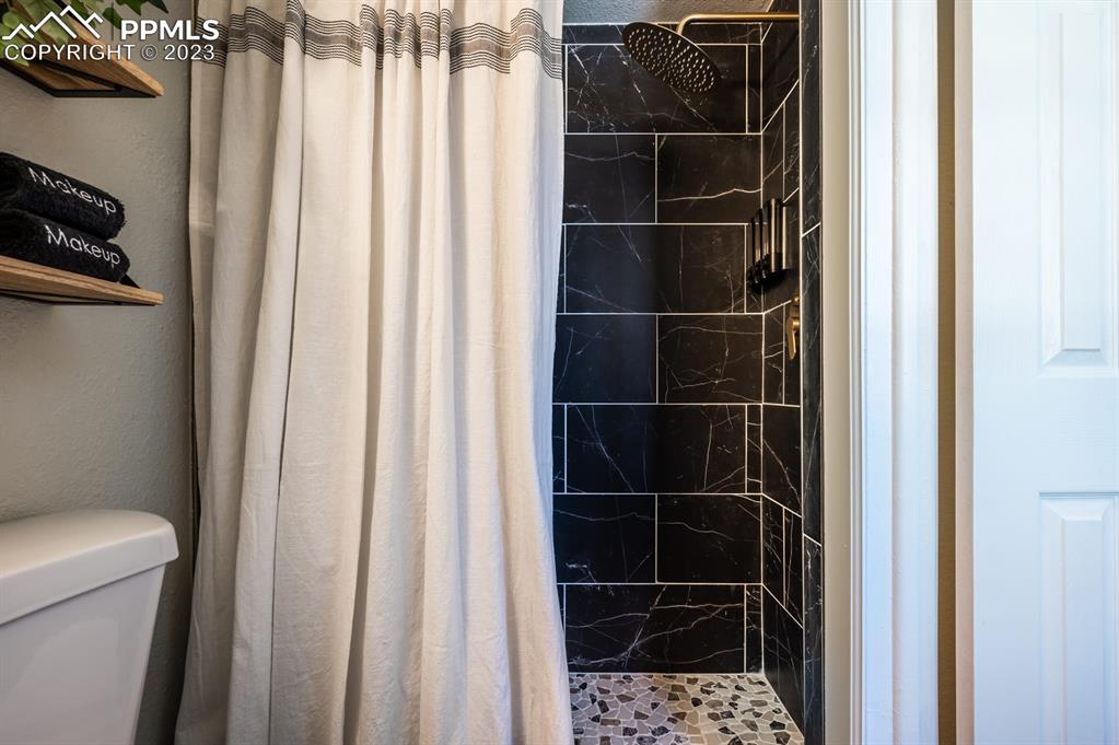 627 Alexander Road Colorado Springs, CO 80909 - Photo 36 of 40 a bathroom with a shower and a toilet